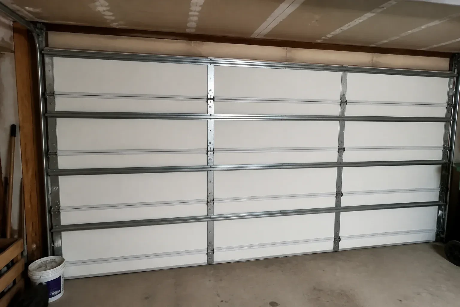 Interior of a closed sectional door with horizontal metal reinforcement struts. — Wind-Rated Garage Door Replacement, Grimsby